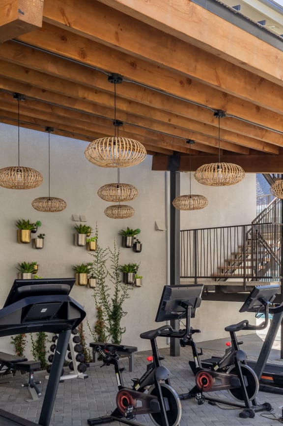 a fitness center with weights machines and a wood roof