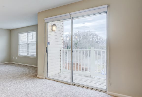 a bedroom with a door leading to a balcony at Sunscape Apartments, Virginia