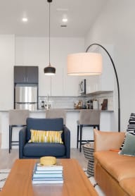 a living room with a couch and a chair and a kitchen