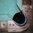 A wooden object with a black handle and a green cloth.