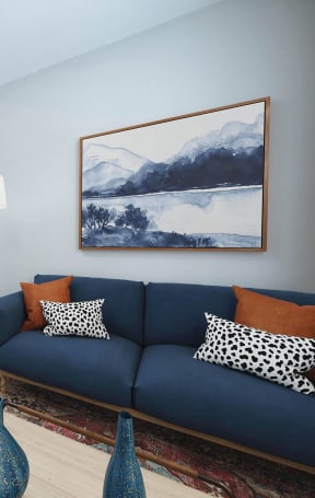 a living room with a blue couch and a table with chairs