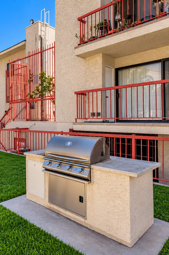 A red metal fence surrounds a small outdoor kitchen.