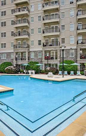 A large swimming pool in front of apartment buildings.