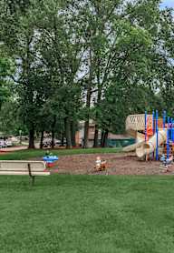 A playground with a slide, swings and a climbing frame.