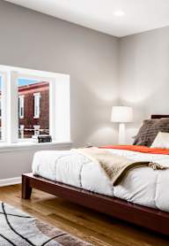 A bedroom with a large bed and a painting on the wall.