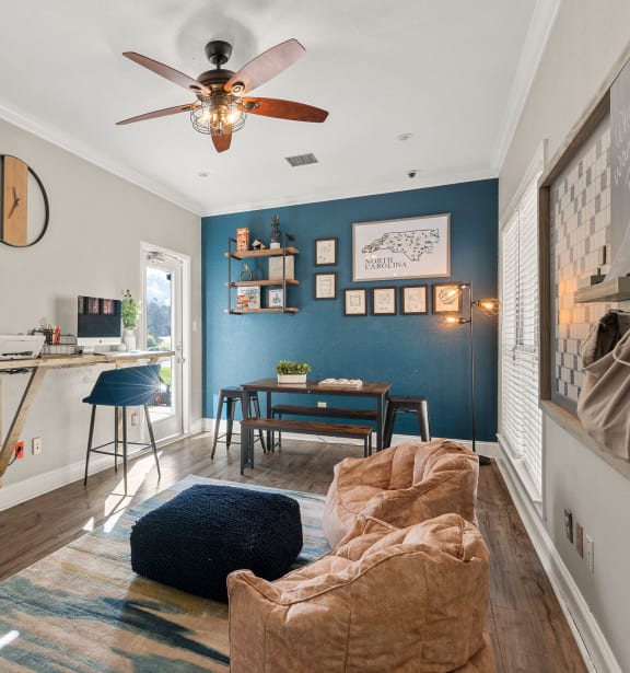 a living room with a couch and a desk and a ceiling fan