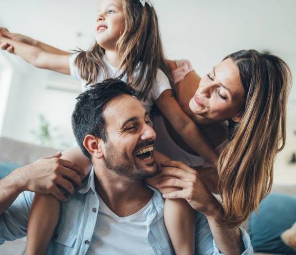 a man and woman with a little girl on his shoulders