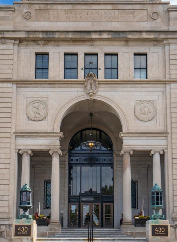 the lobby of a building with paintings on the wall and a bench