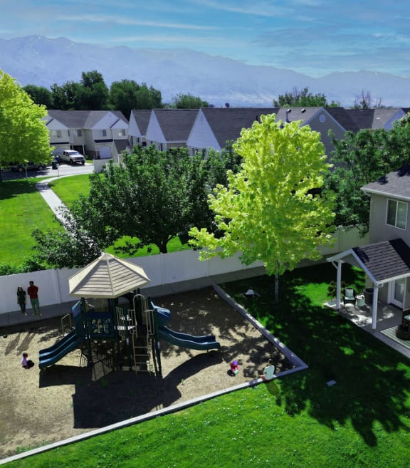 a aerial view of a backyard with a playground and houses