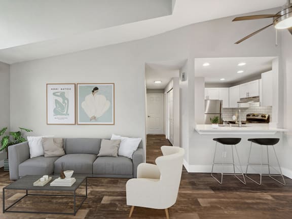  Model Living Room with Wood-Style Flooring, Patio Accessibility and View of Kitchen at Central Flats Apartments in Kent, WA.