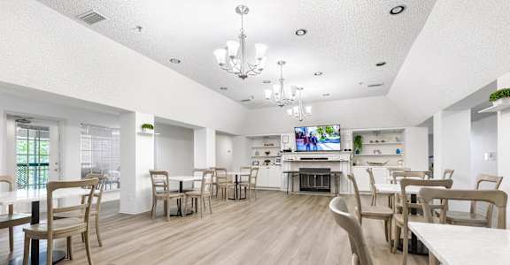 a dining room with tables and chairs and a tv