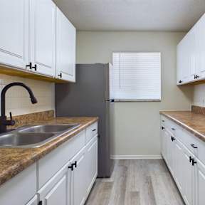 A kitchen with white cabinets and a black stove top oven.