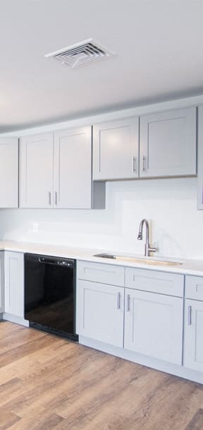 a kitchen with white cabinets and a black stove and refrigerator