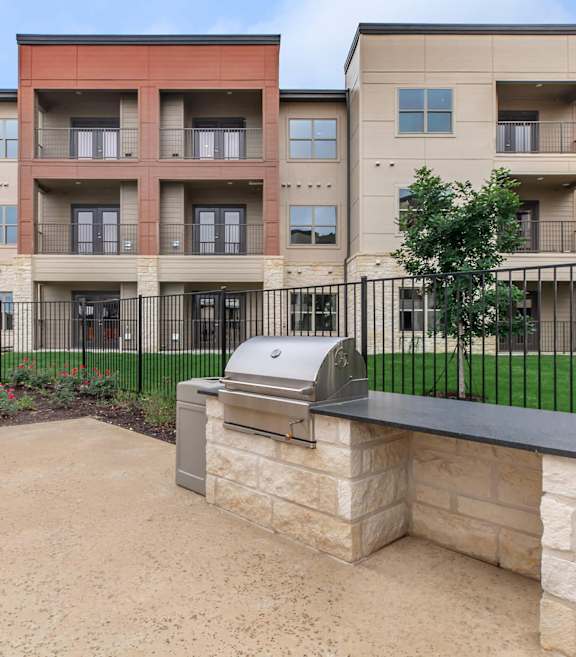 Apartment complex with a stone bench in front. at Sienna at Westover Hills Apartments, San Antonio, TX 78253