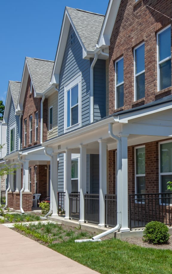 a row of houses with a sidewalk in front of them