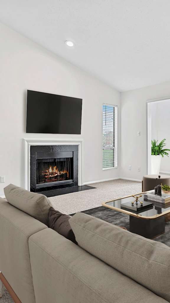 A living room with a fireplace and a television. at Southpark Commons Apartment Homes, Charlotte, 28210