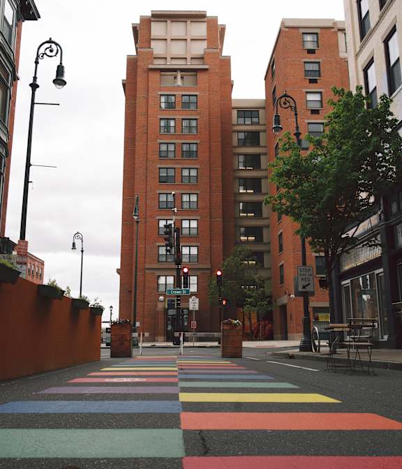 A street with a crosswalk painted in multiple colors.