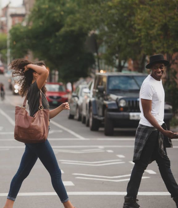 Couple exchanging a laugh while crossing the street