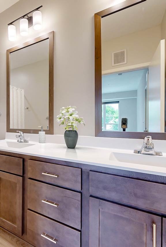 A bathroom with a toilet, sink, and mirror.