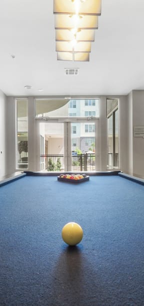 a billiards room with a pool table and a yellow ball