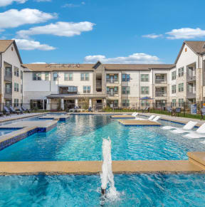 an apartment building with a pool and water fountains