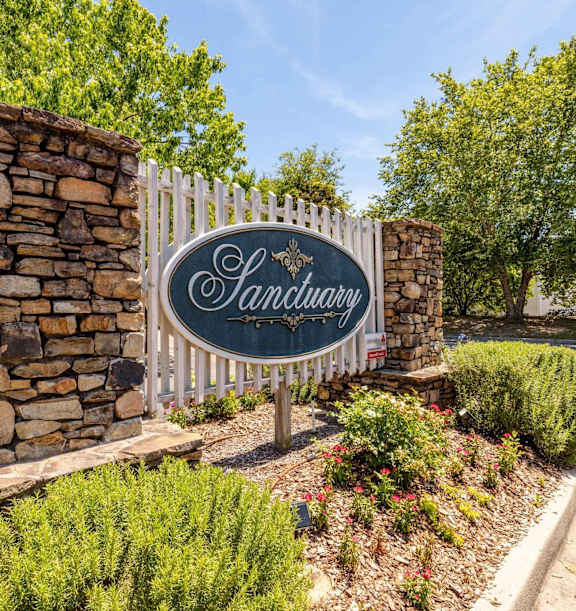 a living room with a large window and a couch and chairs at Sanctuary Apartments & Townhomes, Augusta