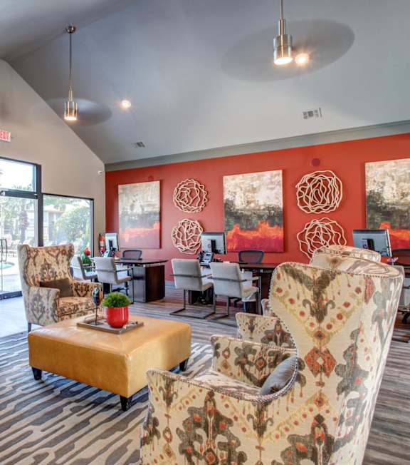 A living room with a yellow couch and a painting on the wall.