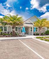 exterior view of swiftwater apartments clubhouse with palm tress in front
