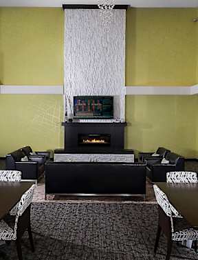 A modern dining room with a fireplace and a large table.