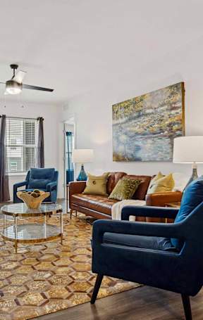 A bedroom with a bed, a chair, and a ceiling fan.