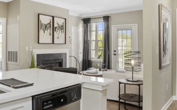 Double Sink With Integrated Sprayer a kitchen with a sink and a dishwasher in front of a living room with a fireplace