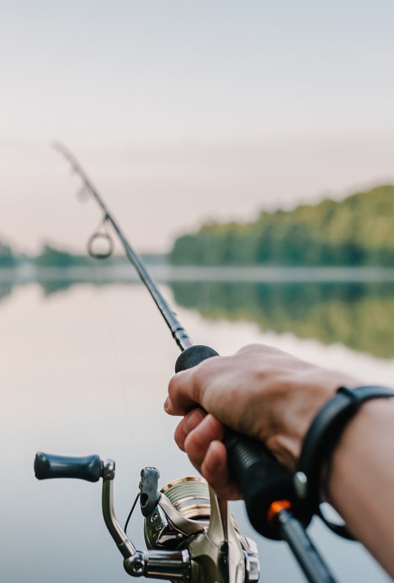 person holding a fishing rod on a lake