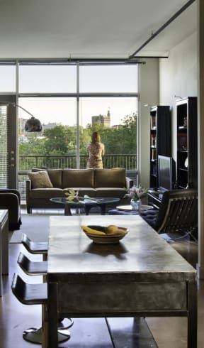 a kitchen and living room with a table and a large window  at 1221 Broadway Lofts, San Antonio