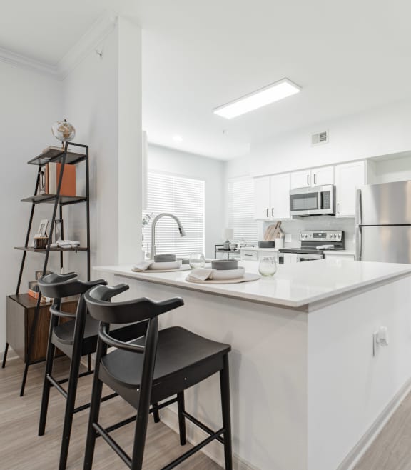 a kitchen with a large island with three stools