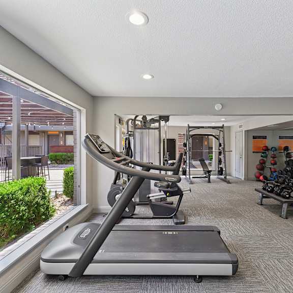 A spacious gym with a variety of equipment and a large mirror on the wall.