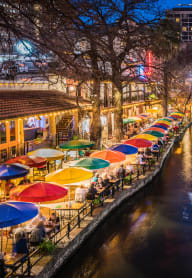 a river running through a city with umbrellas