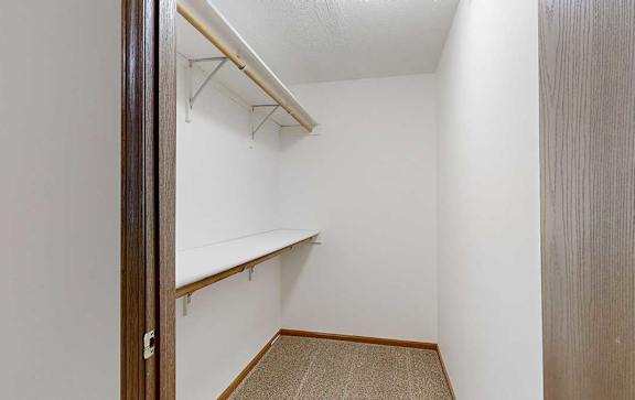 a walk-in closet with built-in shelves and hanging space for ample storage