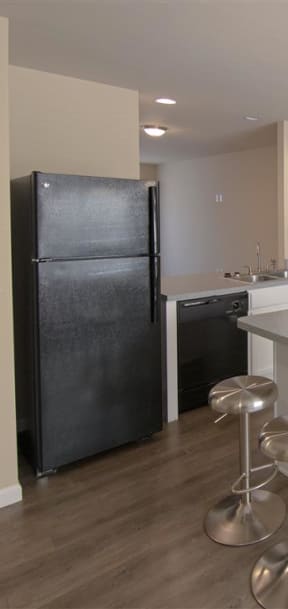 a kitchen with white cabinets and a black stove and refrigerator