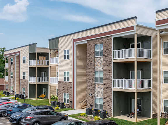 A parking lot with cars and apartment buildings.