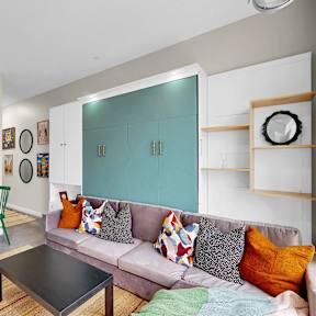 A living room with a grey couch and a green chair.