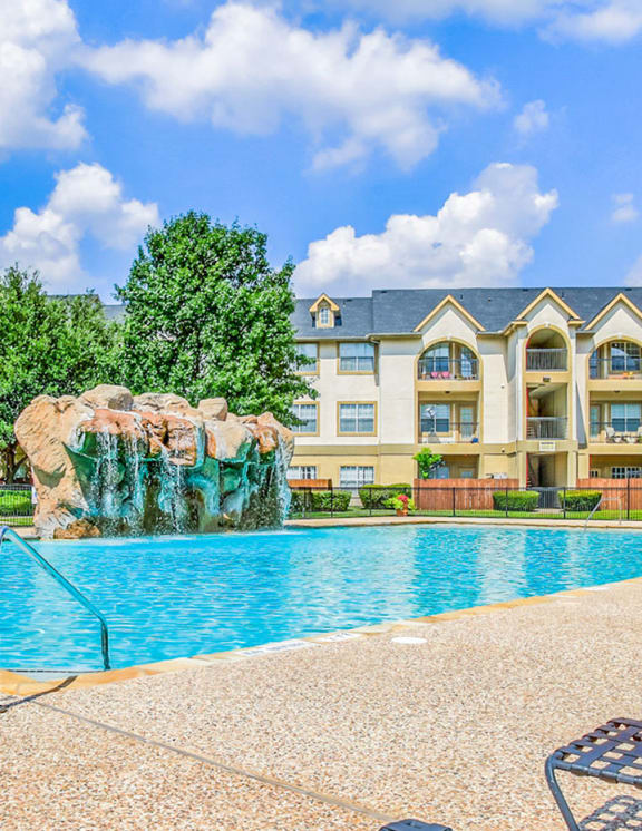 Sparkling pool with a waterfall at Tuscany Square Apartments!