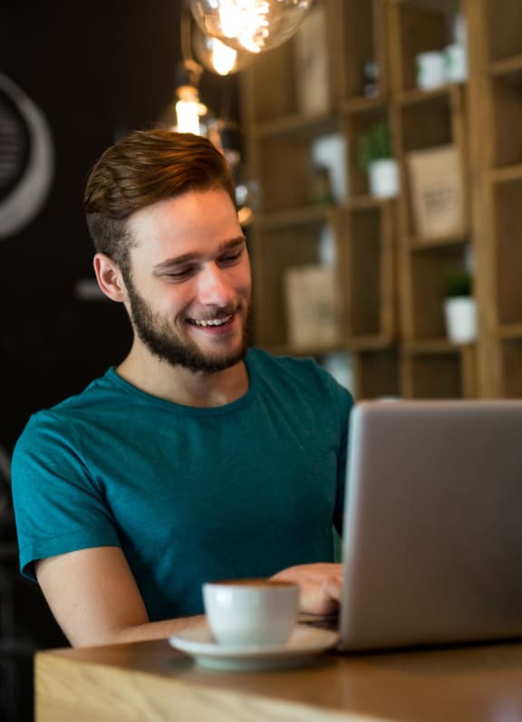 Man Smiling while Working on Laptop