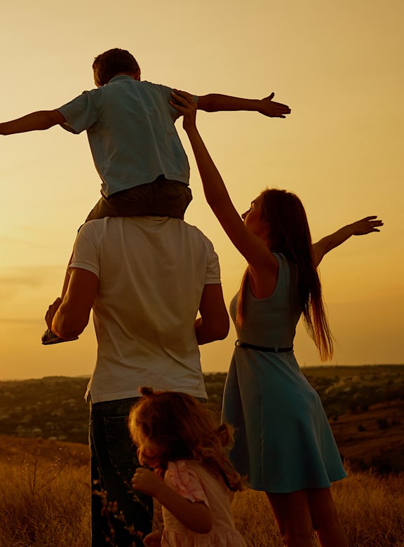 Family enjoying sunset in open field at The Bluewood Apartments, Kerrville, Texas