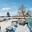 A patio with black furniture and a white railing.