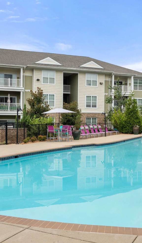 A large swimming pool in front of apartment buildings.