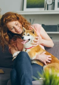 a woman sitting on a couch with her dog at Glen Haven Apts, San Gabriel, CA 91776