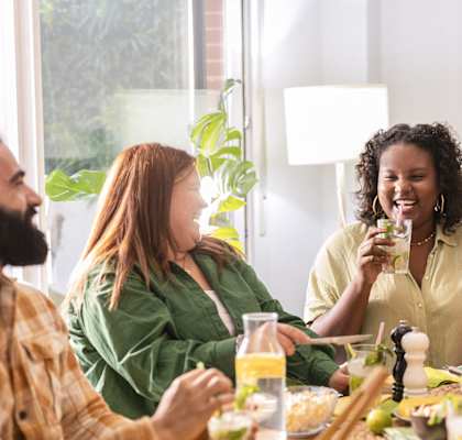 A group of people are sitting around a table eating food.