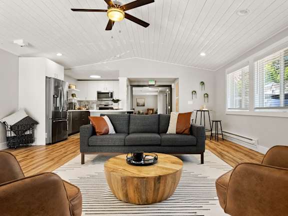 A living room with a grey couch and a wooden coffee table.