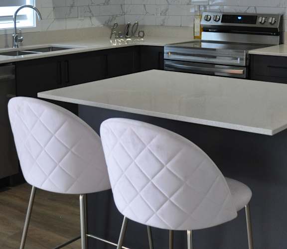 A kitchen with a white countertop and a refrigerator at The Laurent at Laurel Apartments, Edmonton, AB, T6T 2T5