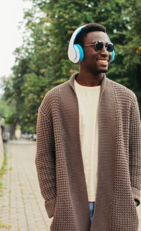 a man wearing headphones walking down the street
